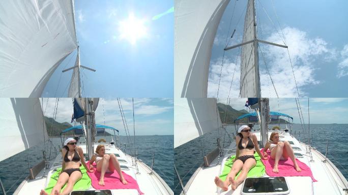 两个年轻女子在一艘帆船的甲板上晒日光浴