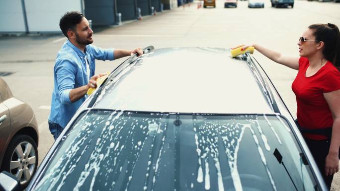 夫妇洗他们的车。