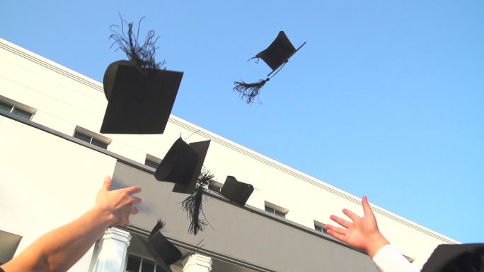 毕业生向空中抛毕业帽。