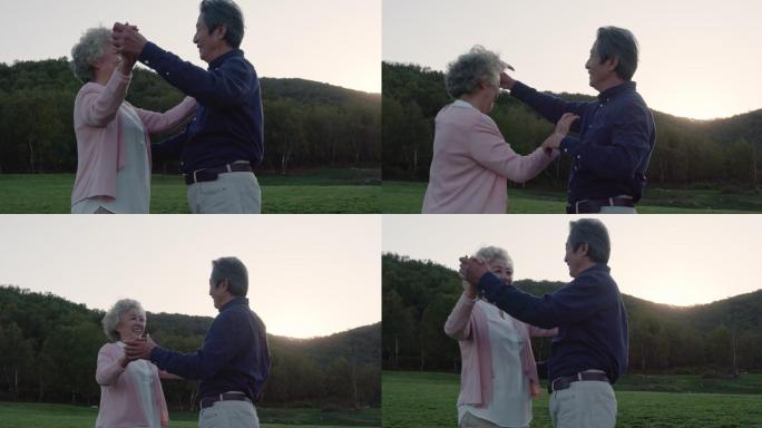 快乐的老年夫妇在草地上跳舞