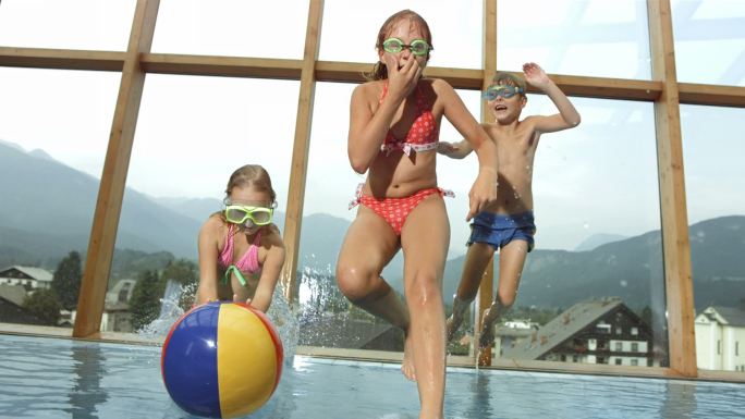 三个孩子跳进游泳池的超级慢镜头