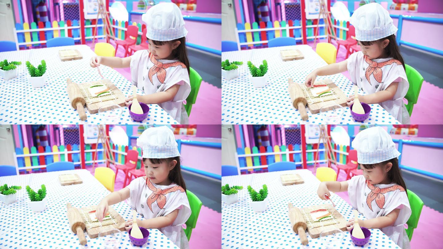 小女孩在做三明治休闲娱乐儿童游戏角色扮演