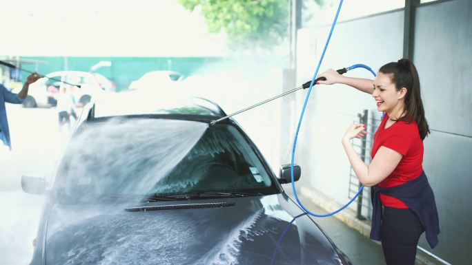 一对妇洗他们的车的特写侧视图。