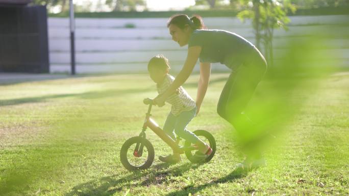 母亲教儿子骑自行车在公园