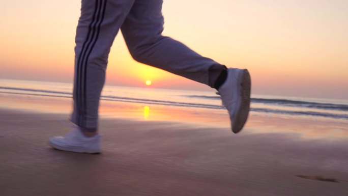 清晨迎着太阳在海边跑步-跑步脚步