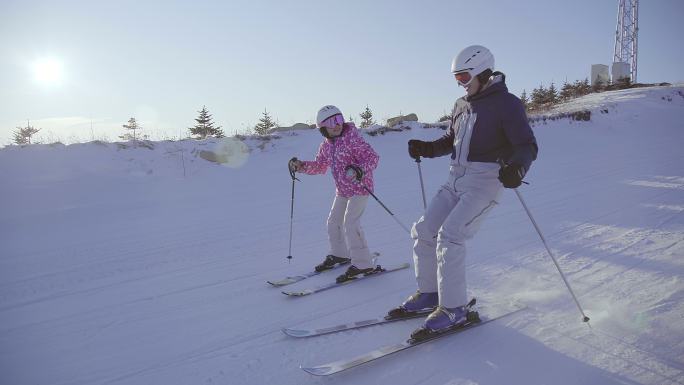 小女孩和爸爸在滑雪场滑雪