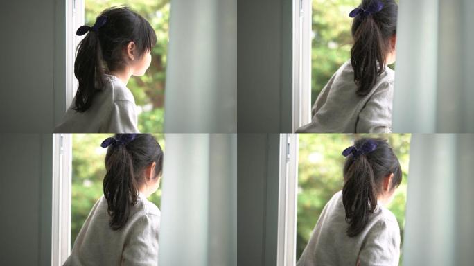 小女孩看着窗外起床窗边小孩