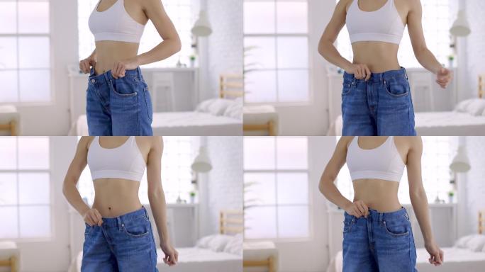 女人穿着大牛仔裤展示她的减肥结果