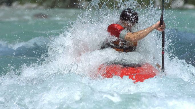 一名职业皮划艇运动员在激流中划着皮划艇