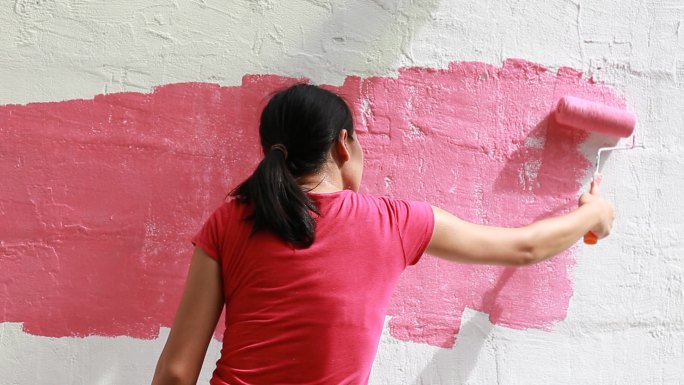 用漆辊将墙面涂成粉红色