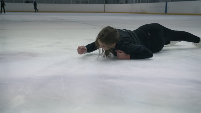 年轻女子在冰上摔倒后站了起来