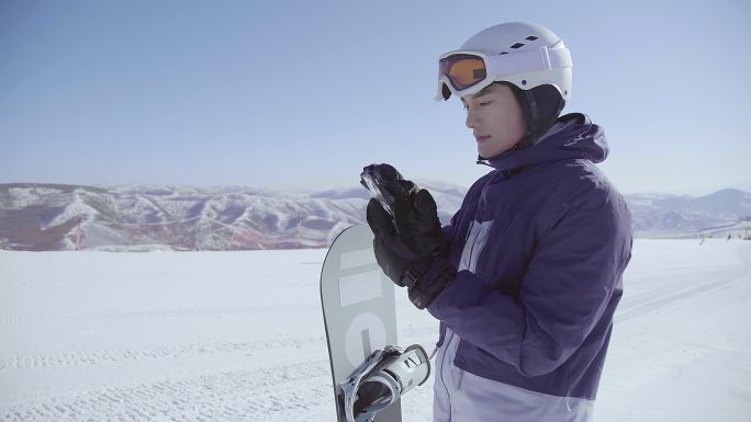 年轻男子在滑雪场使用手机