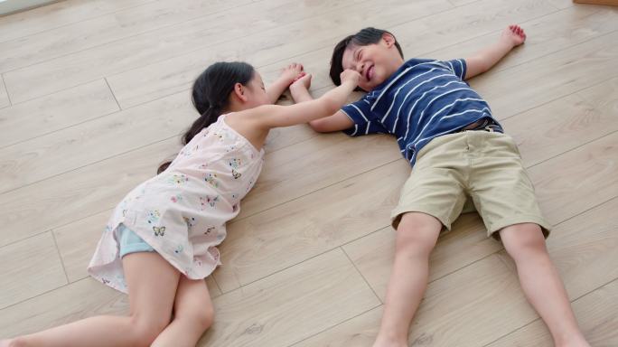 快乐的姐弟俩躺在地板上