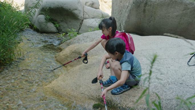 快乐的姐弟俩在溪边玩耍