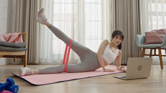 年轻女子在家健身做瑜伽锻炼身体居家休闲