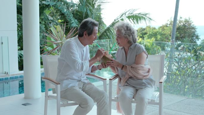 老年夫妇在露台喝椰汁