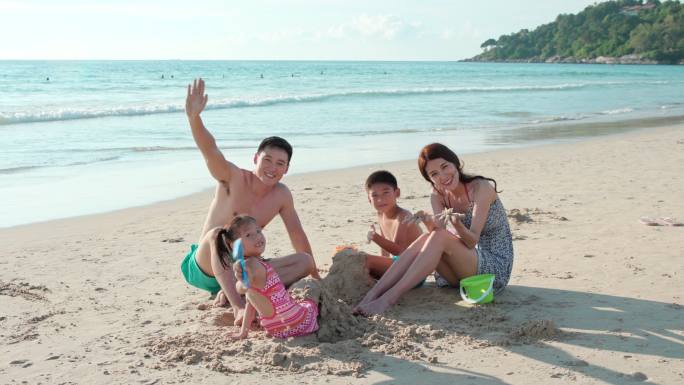 快乐的年轻家庭在海边玩耍