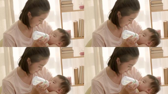 母亲抱着婴儿喂奶喝婴儿奶瓶抱