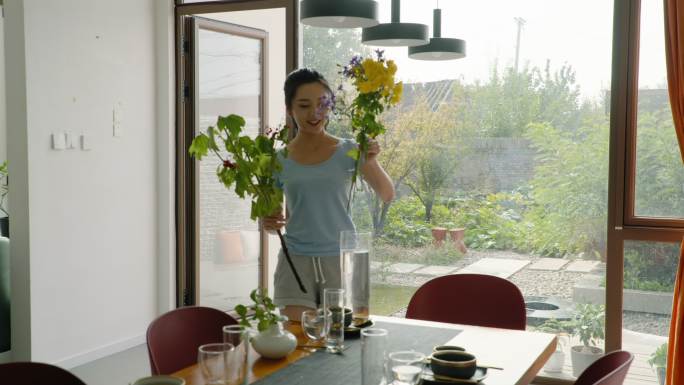 年轻女子用鲜花装饰家里