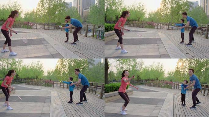 快乐的年轻家庭在公园打羽毛球