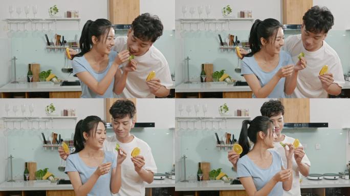 快乐的年轻夫妇在厨房吃水果