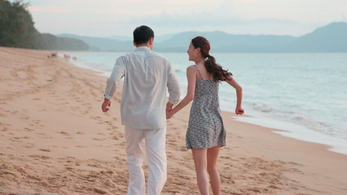 快乐的年轻情侣在海边约会