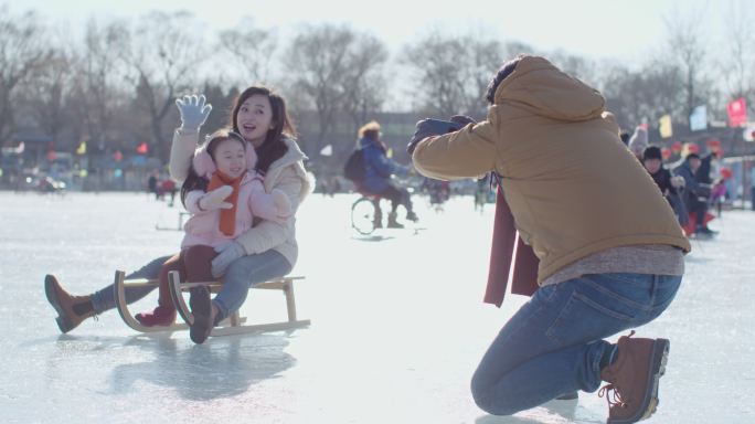 年轻家庭在冰上照相