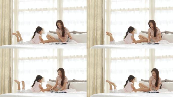快乐的母女俩在卧室叠衣服