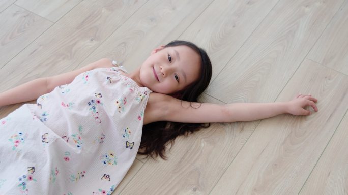 快乐的小女孩躺在地板上