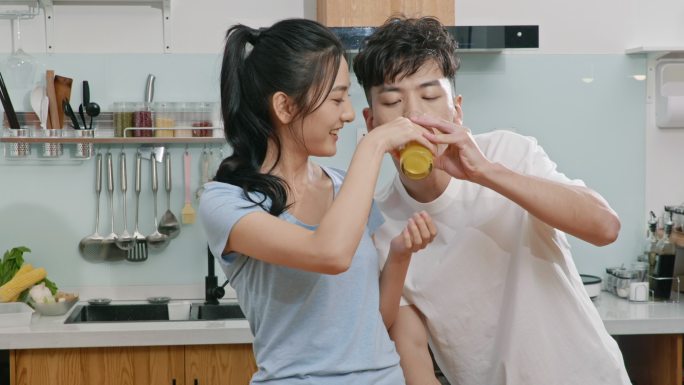 快乐的年轻夫妇在厨房喝鲜榨果汁