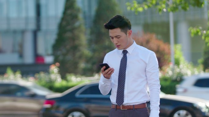 年轻商务男士在街上使用手机