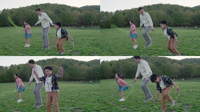 快乐的家庭在草地上比赛跳绳