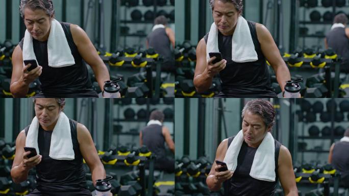 成熟男士在健身房使用手机