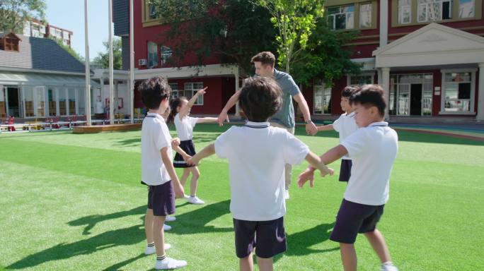 幼儿园外教和学生在操场玩耍