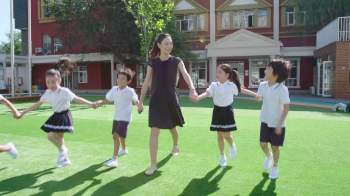 幼儿园老师和学生在操场上