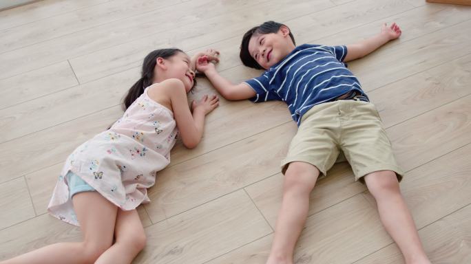快乐的姐弟俩躺在地板上