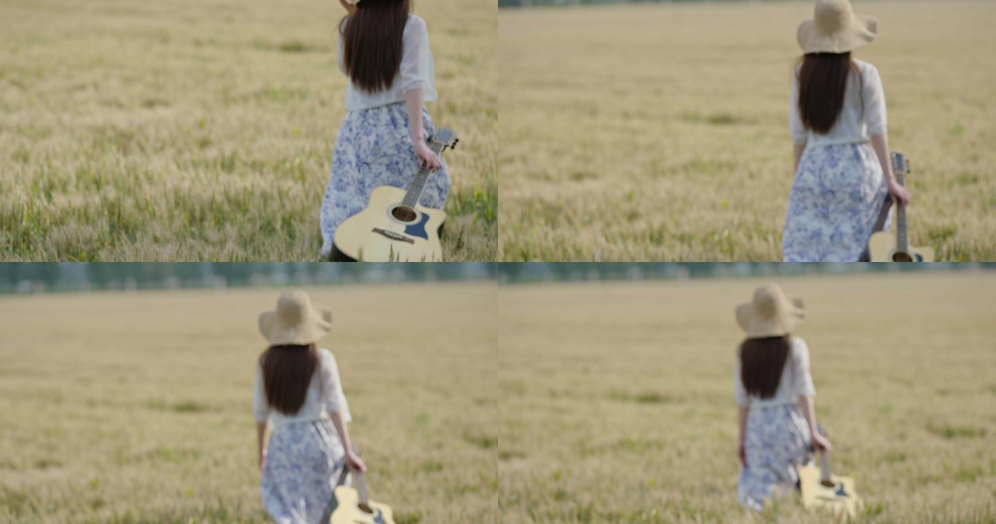 年轻女子拿着吉他在麦田里行走