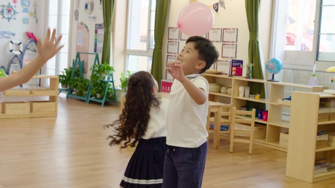 孩子们在幼儿园教室里玩气球