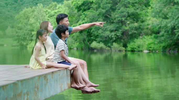 快乐的年轻家庭在河边玩耍