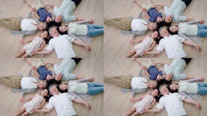 全家人躺在地板上一家人笑容笑脸陪伴父母孩