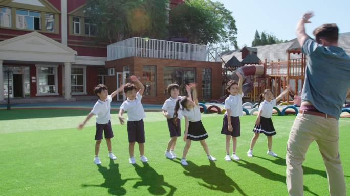 幼儿园老师和儿童在操场做体操