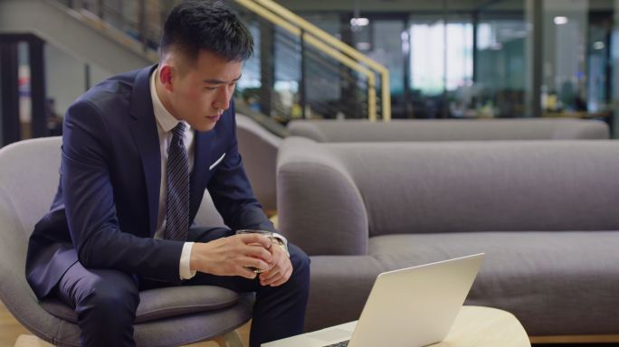 自信的商务男士在办公室喝酒