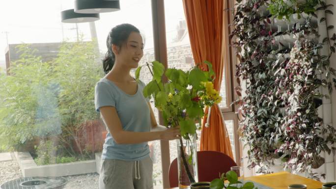 年轻女子用鲜花装饰家里