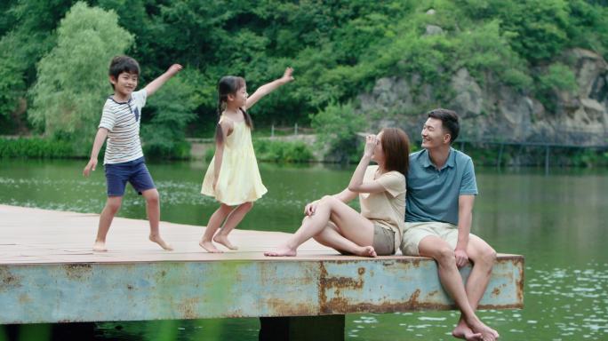 快乐的年轻家庭在河边玩耍