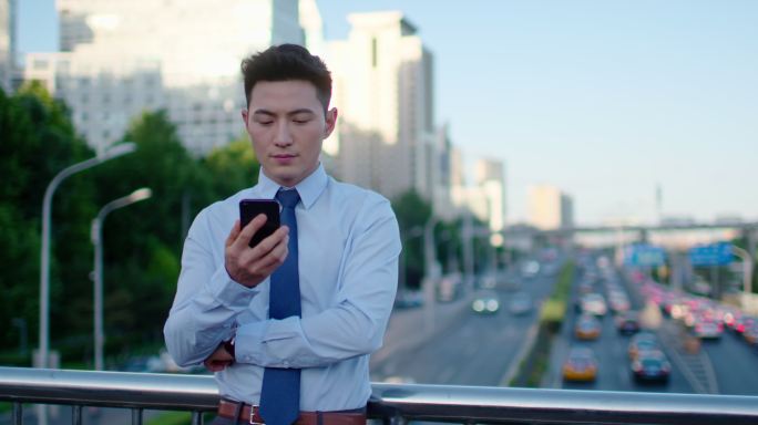 年轻商务男士在户外使用手机