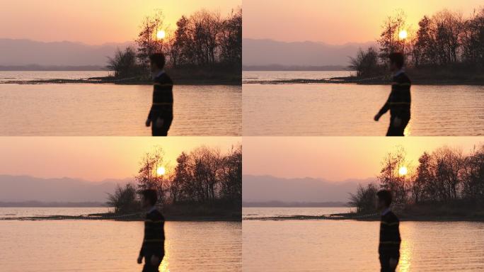 4K日落时分走在湖边的年轻男性