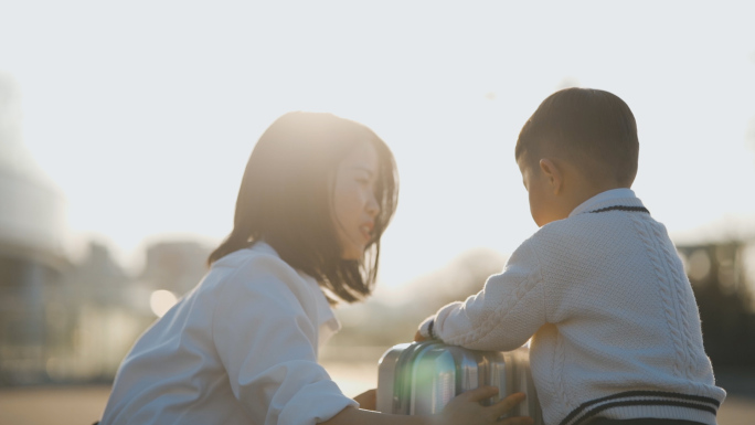 母亲节伟大母爱年轻父母亲吻小孩逆光背影