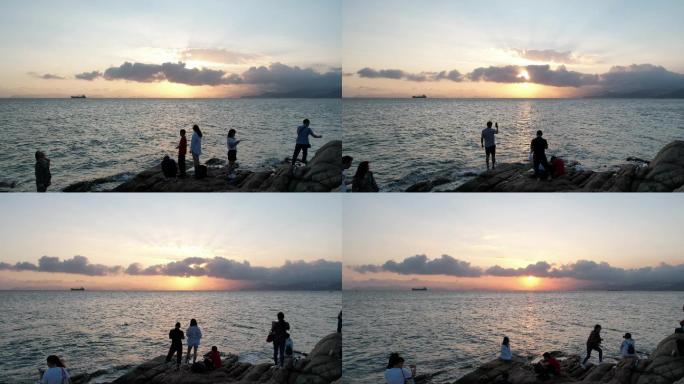 深圳大鹏半岛官湖海滩游客欣赏海上落日延时