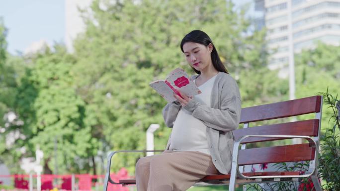 孕妇坐在长椅上看书