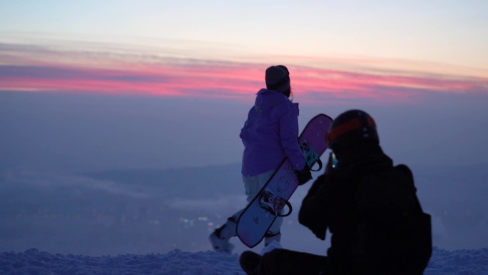 滑雪的女孩看在山顶看晚霞
